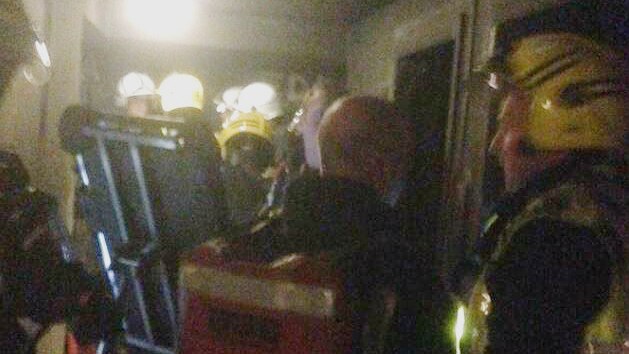 Firefighters are seen planning assumedly in a hallway of a lower floor of the grenfell tower