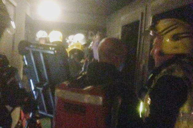 Firefighters are seen planning assumedly in a hallway of a lower floor of the grenfell tower