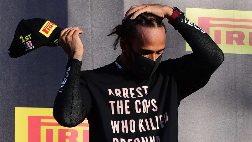 Lewis Hamilton wearing a black mask and black shirt saying 'Arrest the cops who killed Breonna Taylor'.