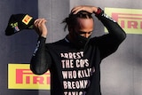 Lewis Hamilton wearing a black mask and black shirt saying 'Arrest the cops who killed Breonna Taylor'.