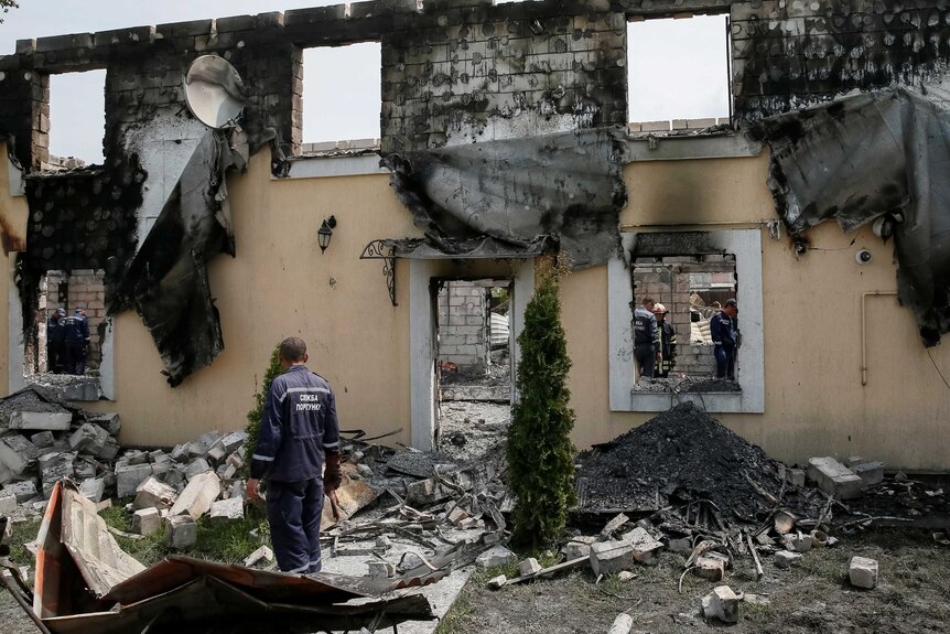 Firefighters work in a burned residential building in Litochky in Ukraine.