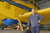 He stands next to the yellow plane