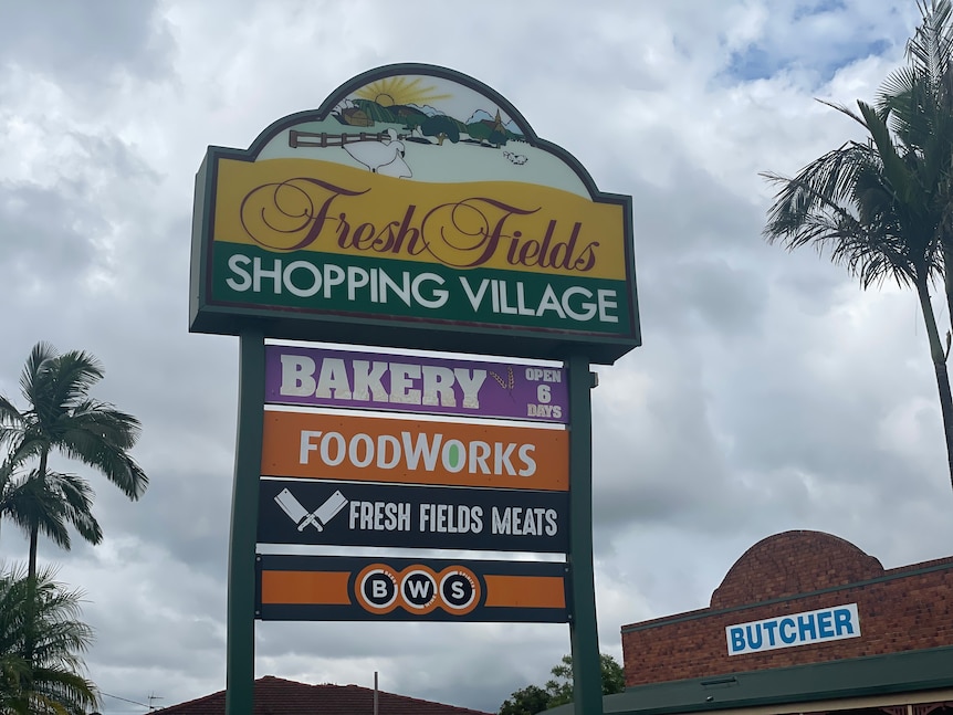 A colourful shopping centre sign that reads "Fresh Fields Shopping Village".