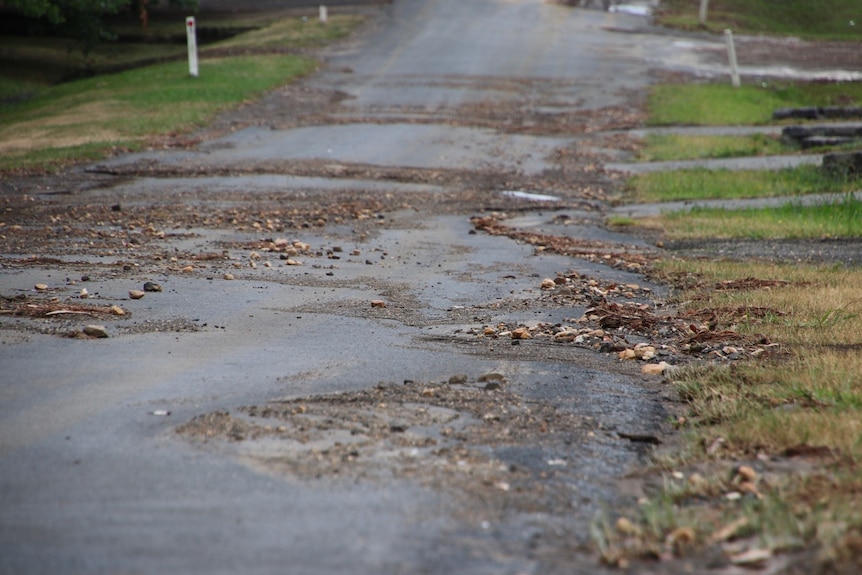 A road covered in debris left behind by flash flooding.