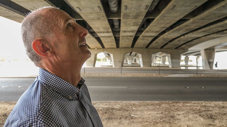 Engineer Duncan Robinson looks up at the underside of the Narrows Bridge