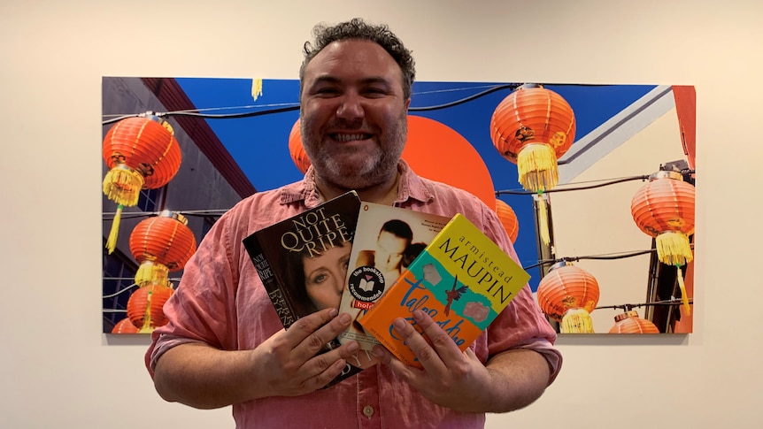 Trevor Ashley holding his three favourite books