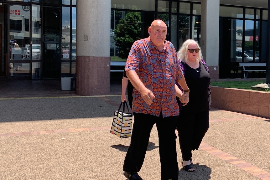 People leaving a court building on a sunny day.