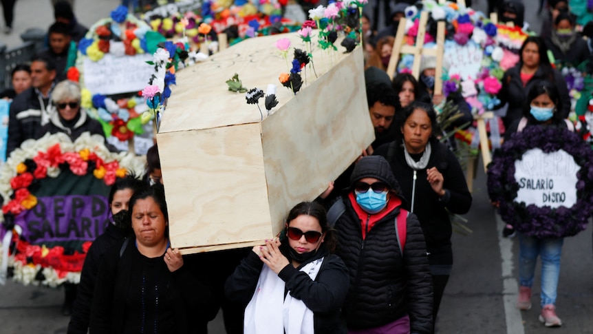 Demonstrators carry a coffin during a symbolic funeral.