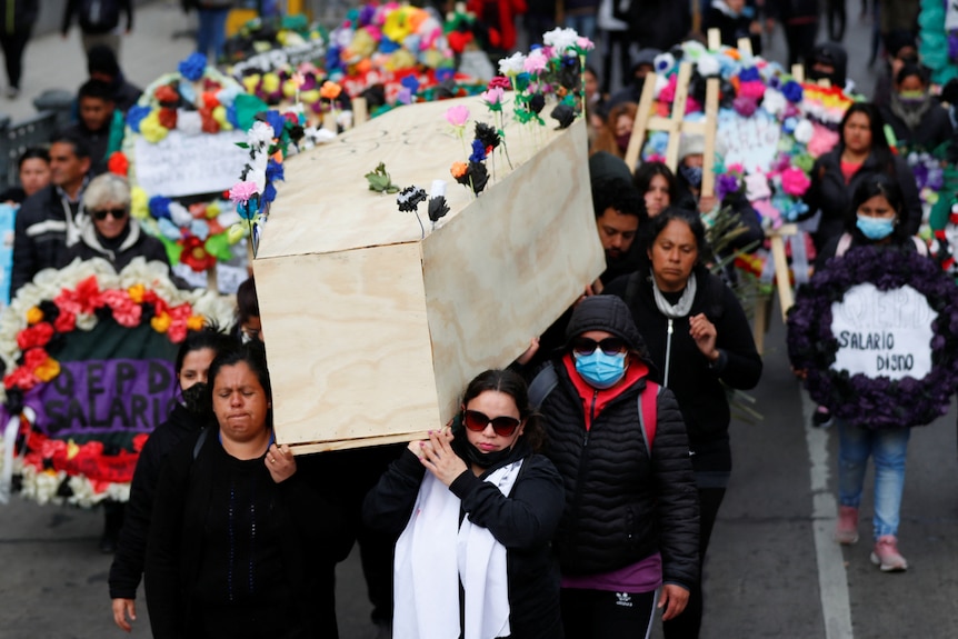 Demonstrators carry a coffin during a symbolic funeral.