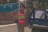 A police officer checks a four-wheel-drive allegedly use to run down two people at Snowtown, where two other people were also stabbed