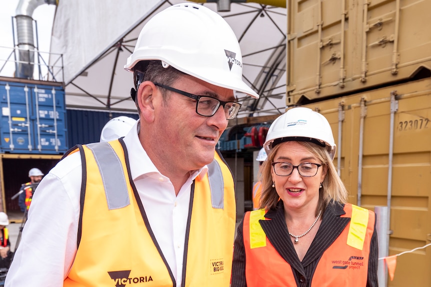 Daniel Andrews and Jacinta Allan side-by-side at a press conference around shipping containers.
