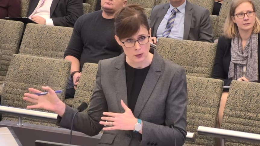 Barrister Rowena Orr standing in front of rows of seats