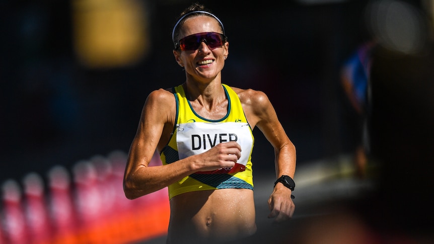Sinead Diver smiles as she runs, wearing sunglasses