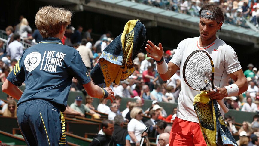 Rafael Nadal is given a towel during his French Open first round match against Daniel Brands.
