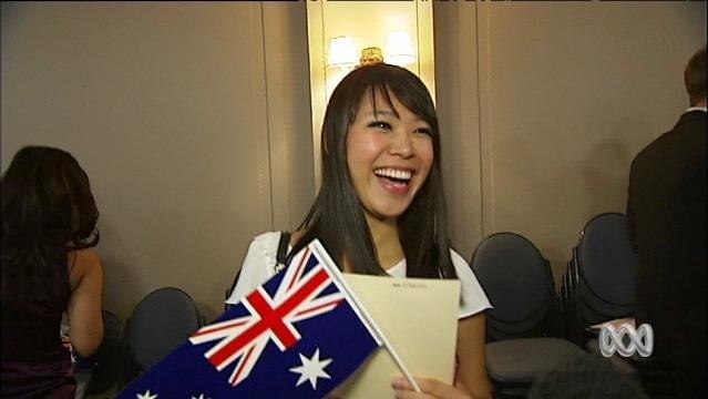 Smiling woman holds Australian flag