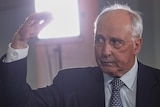 Paul Keating gestures with one hand up and one pushing down, eyebrows raised looking at the ABC hosts.
