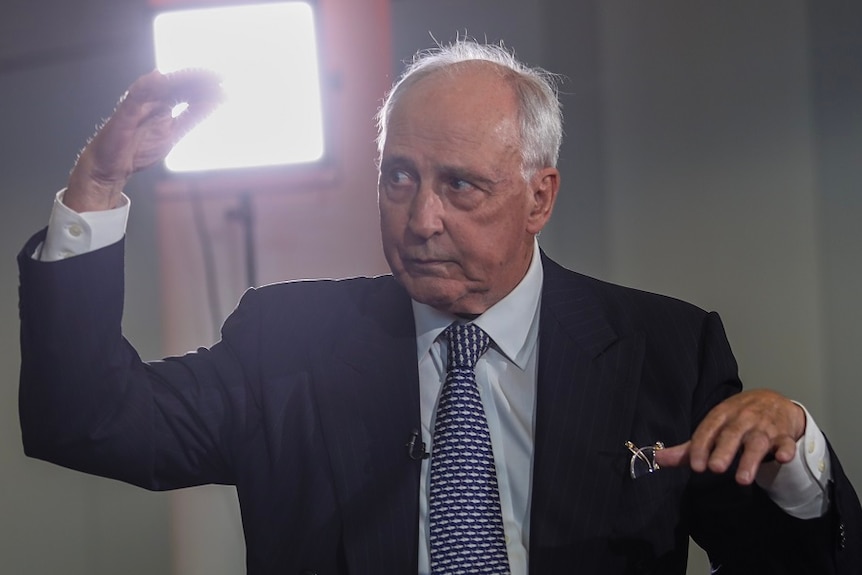 Paul Keating gestures with one hand up and one pushing down, eyebrows raised looking at the ABC hosts.