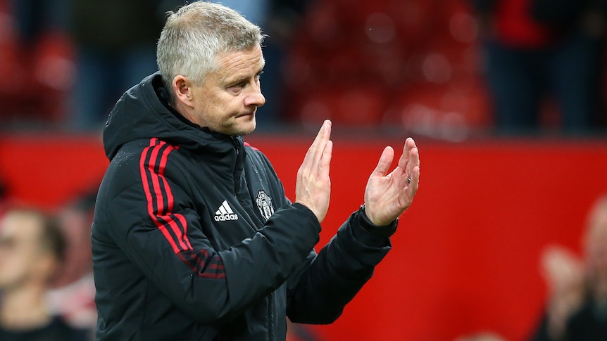 Ole Gunnar Solskjaer applauds the crowd while wearing a frown