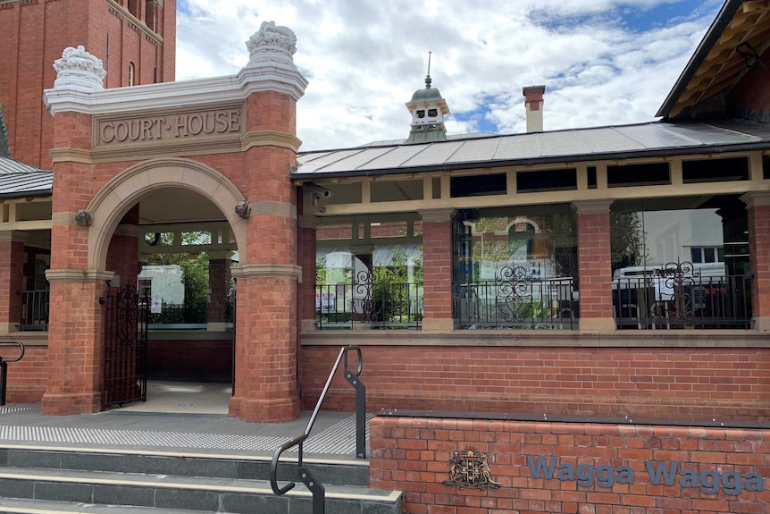 A arched gateway to a red brick building, sign reads "Wagga Wagga"