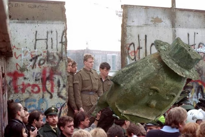 A mock up showing a large potato sculpgture falling at the Berlin Wall