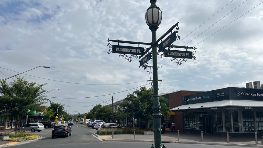 Ornate green street sign and lamp in foreground with warragul street in the background