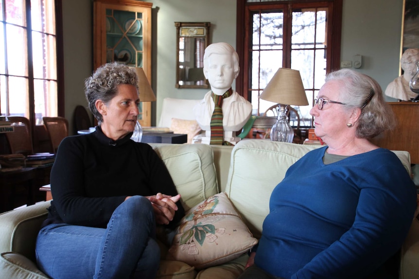 Kate Engelbrecht sits with a friend in her home.