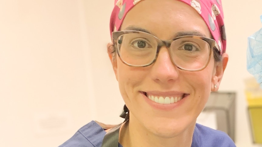 A close up of a smiling woman wearing glasses and a pink headscarf