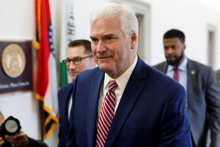 tom emmer in suit and tie walks through congress with other men in suits 