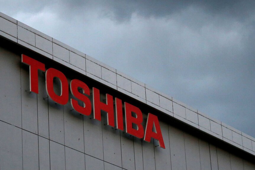The Toshiba Corporation logo in front of dark skies.