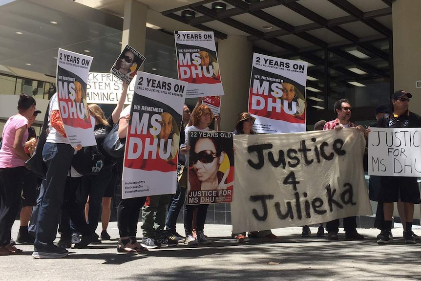 A group of people holding placards and banners in support of Ms Dhu.