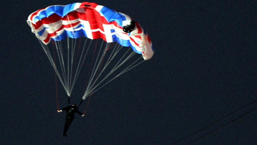 A parachutist dressed as James Bond jumps out of a helicopter and descends into the Olympic stadium in London