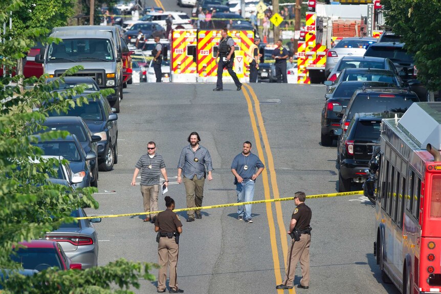 Police and emergency personnel are seen in a cordoned off area.