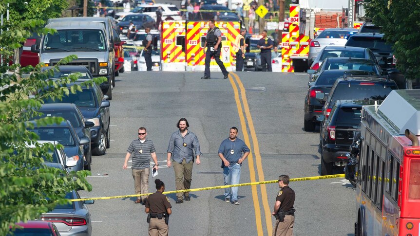 Police and emergency personnel are seen in a cordoned off area.