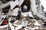 Students walk out from a collapsed building