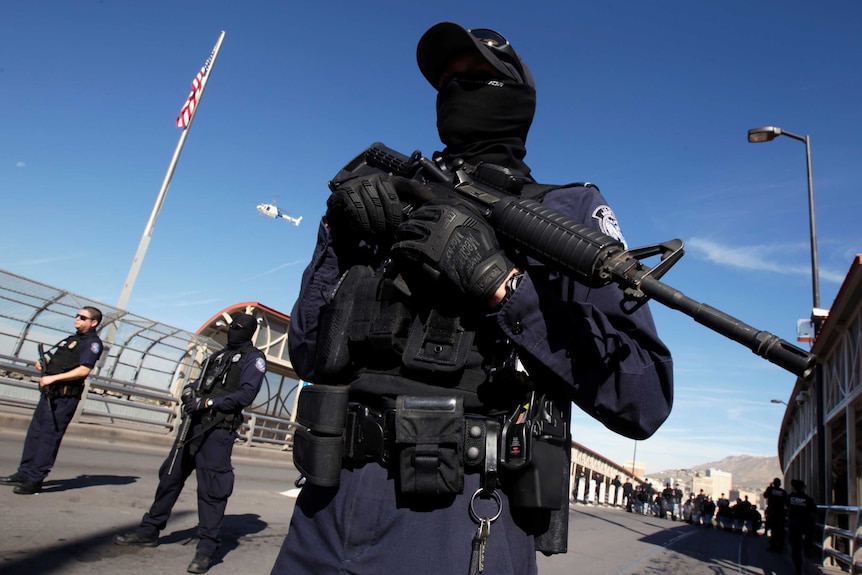 Masked border agents with guns on a training drill.