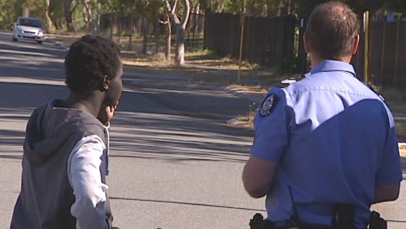 A police officer chats to one of the boys who found the bashed teen