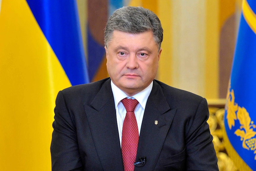 Petro Poroshenko in a black suit in front of the Ukrainian flag addresses a speech to camera