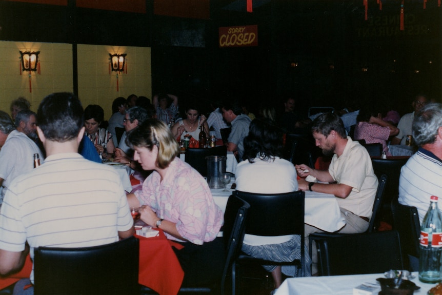 A group of restaurant tables packed with people.