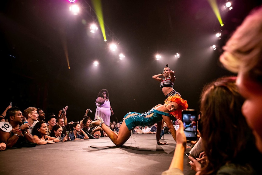 A crowd of attendees look on as Bhenji Ra poses on the runway at Sissy Ball 2019.