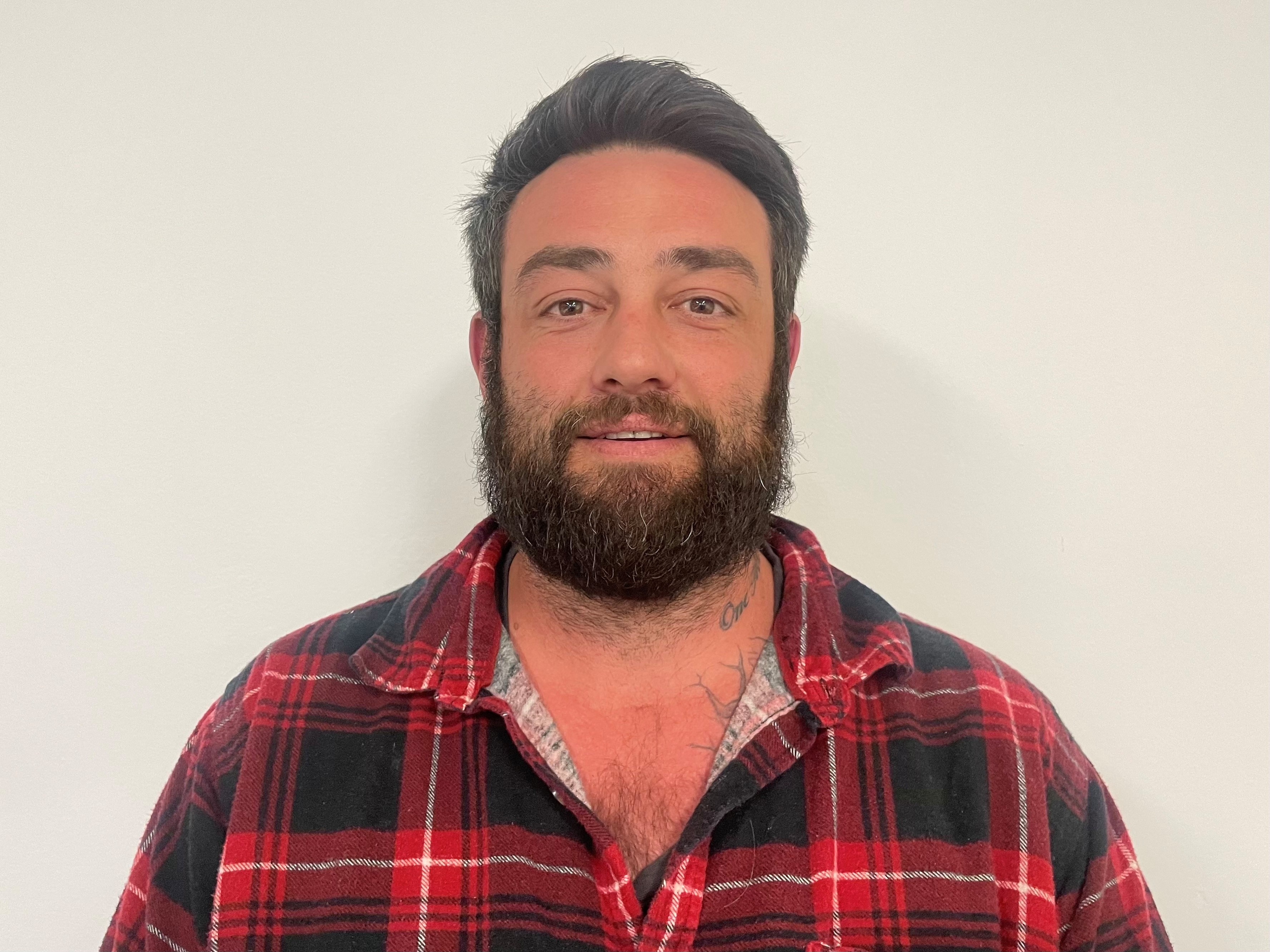 hardwood timber A man with a beard in a red flannel shirt.