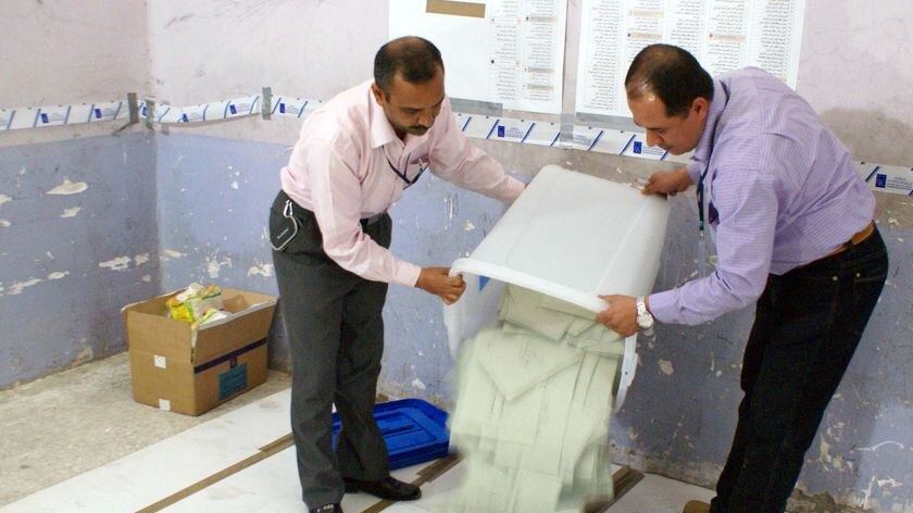 Employees of the Independent High Electoral Commission (IHEC) empty a ballot box
