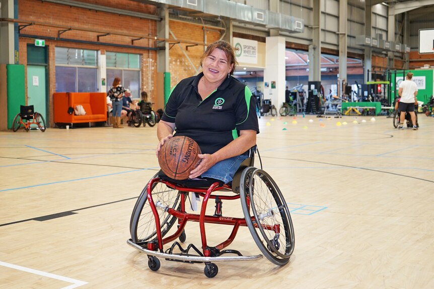 Wendy Passfield holding a basketball on an indoor court.