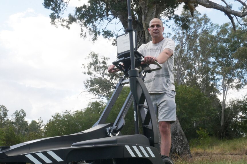 Daniel Thompson stands behind a Ground Penetrating Radar (GPR) scanner at Shapcott Park in Ipswich, west of Brisbane.