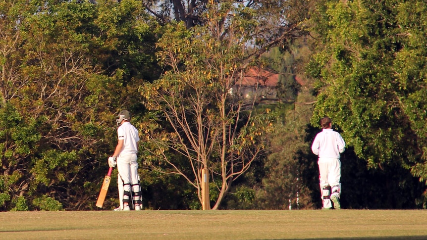 Batsman and wicketkeeper on the field during a grade cricket match.