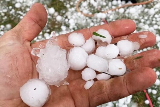Hail stones in a hand and on the ground at Mt Tyson, west of Toowoomba.