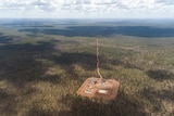 An aerial view of an exploration well in the Northern Territory's Beetaloo Basin on a patch of cleared land surrounded by bush