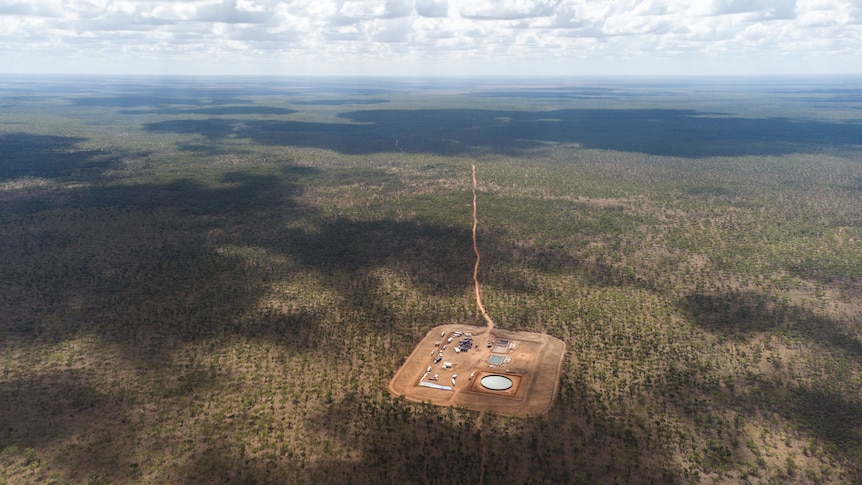 An aerial view of an exploration well in the Northern Territory's Beetaloo Basin on a patch of cleared land surrounded by bush