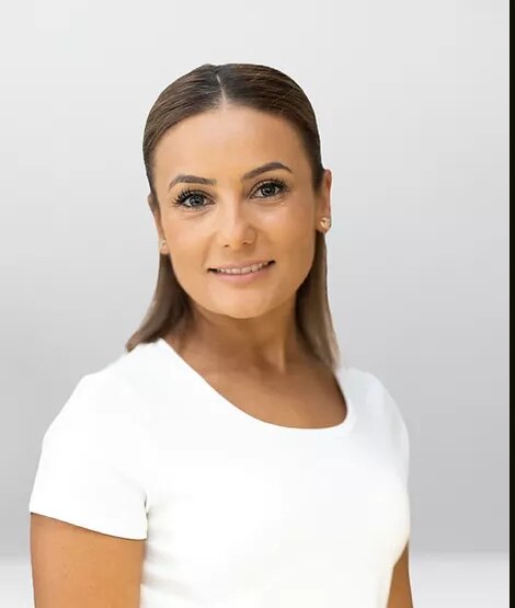 A woman smiling with her hair and make up done nicely