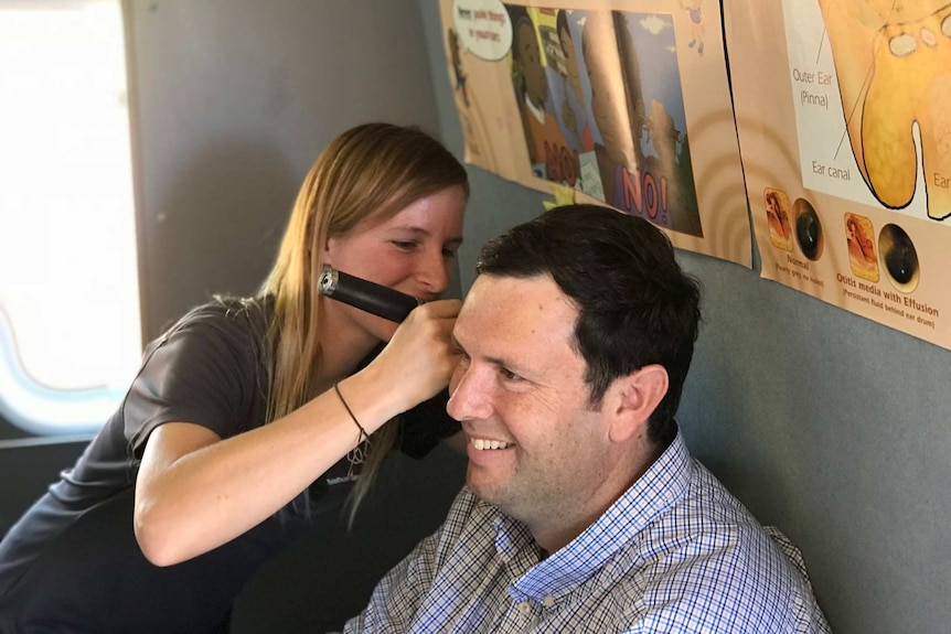 Pilbara ear health coordinator Amelia Scheele tests the hearing of Roebourne school principal David Paine