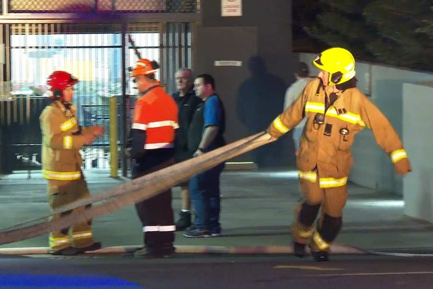 fireman dragging a hose across a street